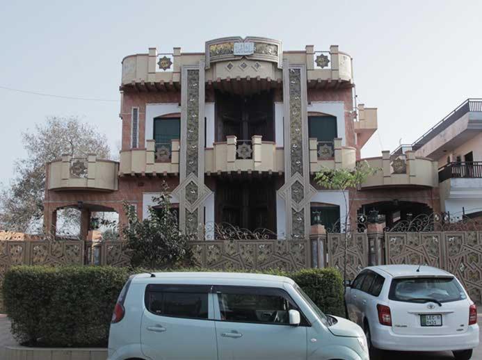 una furgoneta blanca estacionada frente a un edificio en Butt Lodges 3 en Islamabad