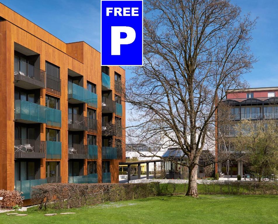 ein Gebäude mit einem kostenlosen Parkschild neben einem Baum in der Unterkunft Newstar Hotel (Free Parking) in St. Gallen