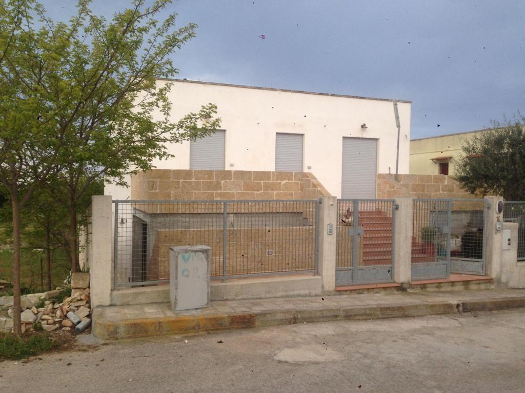 einen Zaun vor einem weißen Gebäude in der Unterkunft Appartamenti Torre Lapillo in Torre Lapillo