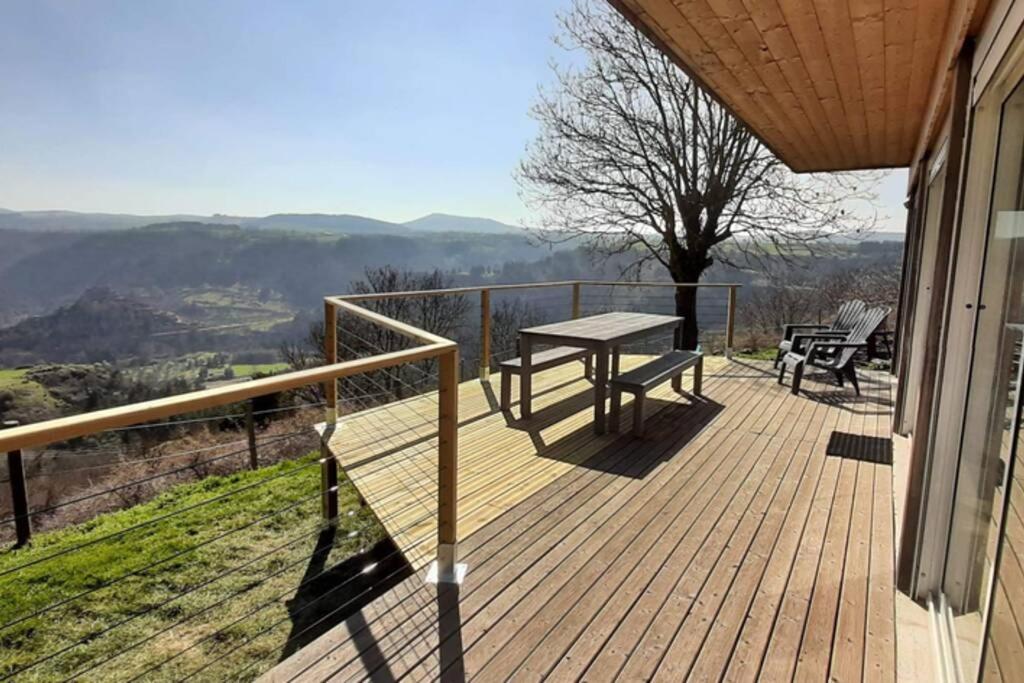 une terrasse en bois avec une table et un banc sur une maison dans l'établissement MacQuart P.O.A. RANCH Gîte de 2 à 8 pers, à Saint-Martin-de-Fugères