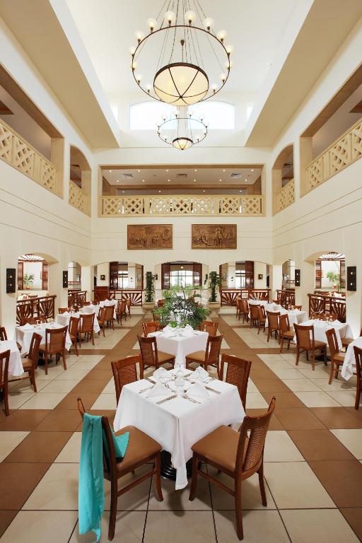 a restaurant with tables and chairs and a chandelier at Sharm Grand Plaza Resort - Families and Couples Only in Sharm El Sheikh