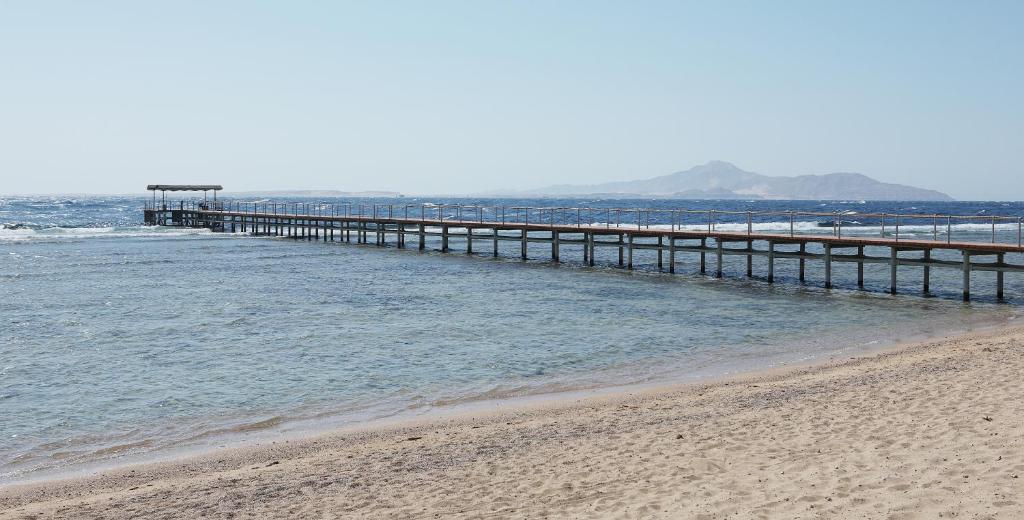 a pier stretches out into the ocean on a beach at Sharm Grand Plaza Resort - Families and Couples Only in Sharm El Sheikh