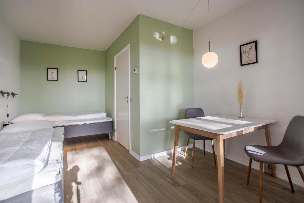 Zimmer mit einem Bett, einem Schreibtisch und einem Tisch in der Unterkunft Lindvig - Ferie i naturen in Nymindegab