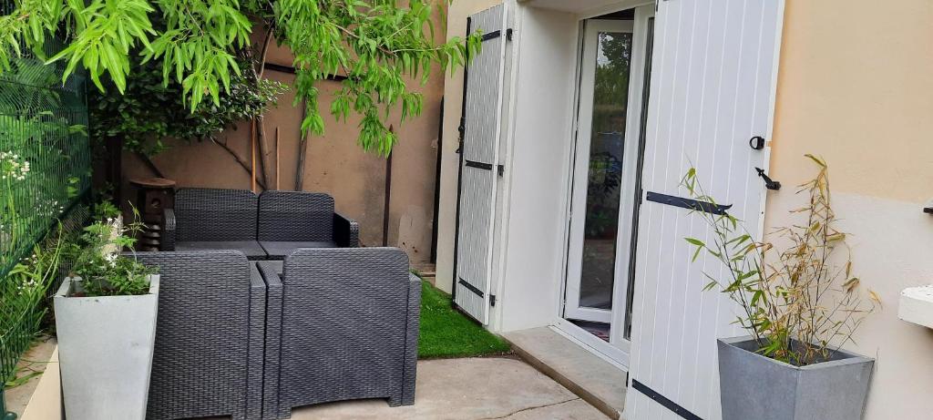 d'une terrasse avec 2 chaises en osier et une table. dans l'établissement Appartement Arles 35 m2, à Arles