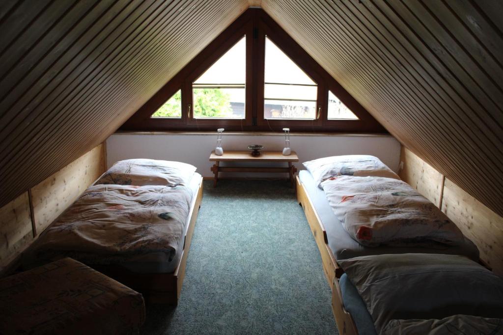 a attic room with three beds and a table at Ferienhaus Dani in Bad Gottleuba