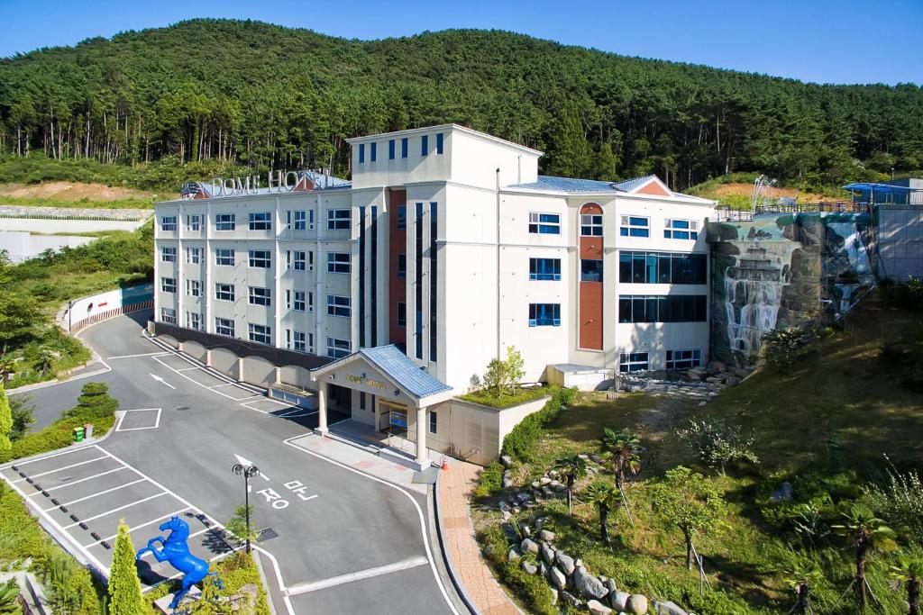 an aerial view of a hotel on a hill with a street at Dome Hotel Geoje in Geoje