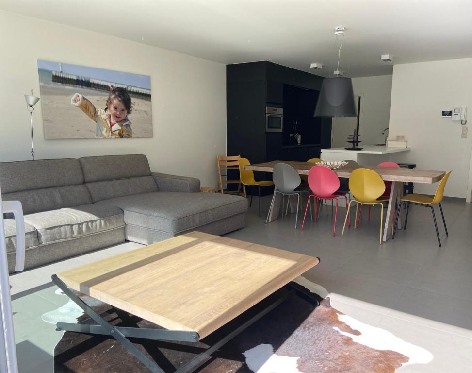 un soggiorno con divano e tavolo di Dolce Vita - zonnig familie appartement met garagebox a Nieuwpoort