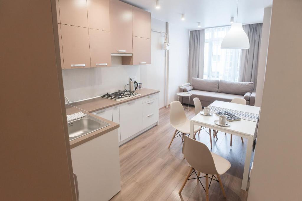 eine Küche und ein Wohnzimmer mit einem Tisch und Stühlen in der Unterkunft Scandinavian apartment Elegant in Lwiw