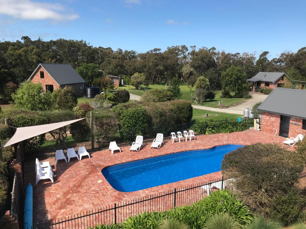 een uitzicht over een zwembad met ligstoelen en een zwembad bij Prom Coast Holiday Lodge in Waratah Bay