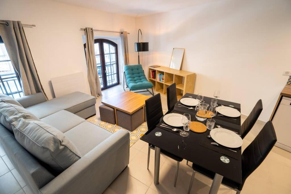 uma sala de estar com um sofá e uma mesa em La veilleuse - Appartement au cœur du centre ville em Limoges