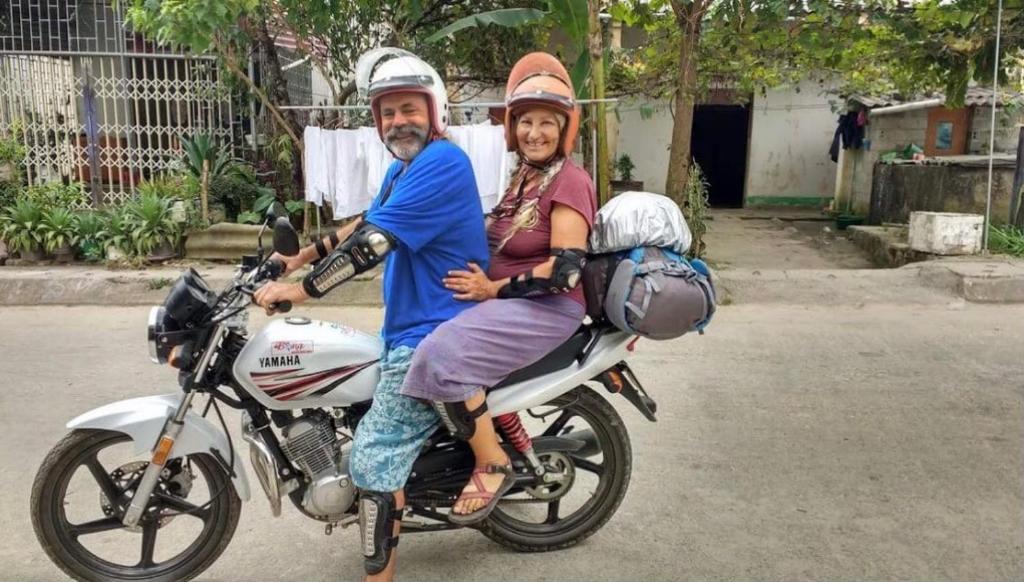 a man and a woman sitting on a motorcycle at Meo Vac Cosy Hostel in Mèo Vạc