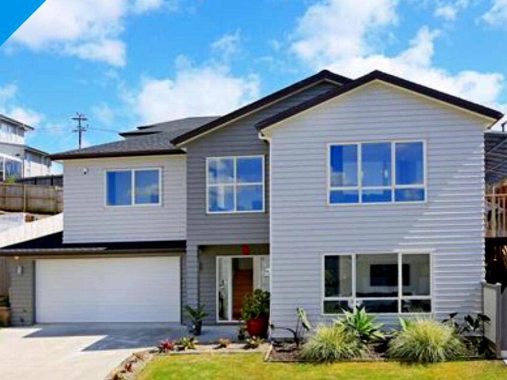 a white house with a white garage at The Rise BNB - Executive Ensuite in Auckland