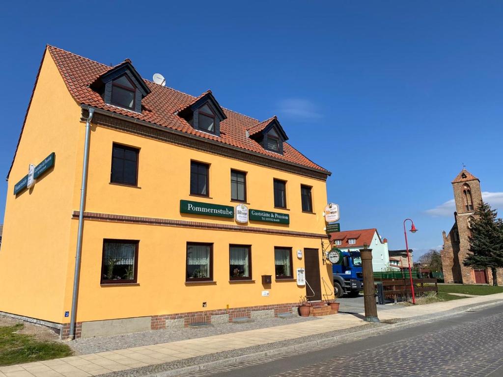 un edificio giallo sul lato di una strada di Gaststätte & Pension Pommernstube a Gartz an der Oder