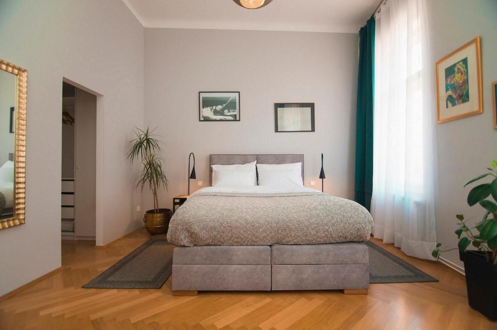 um quarto com uma cama grande num quarto em Stross Apartments em Zagreb