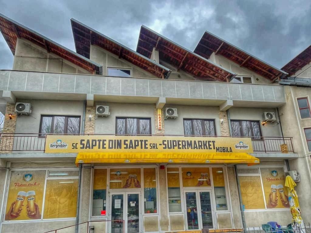 a building with a sign in front of it at Casa Șapte din Șapte in Curtea de Argeş
