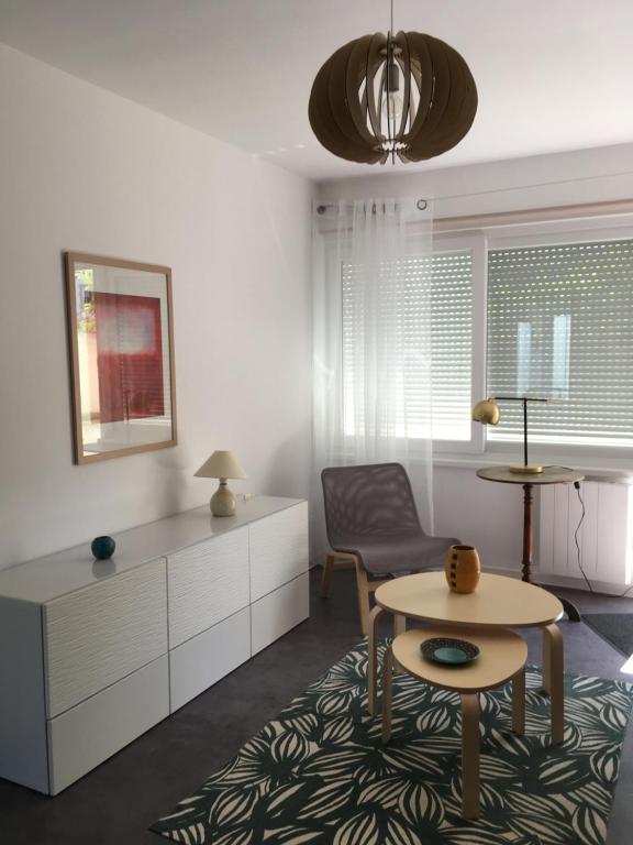 a living room with a table and a chair at Pyramides, maison de ville de charme 6pers, 2 Chambres, terrasse in Mulhouse