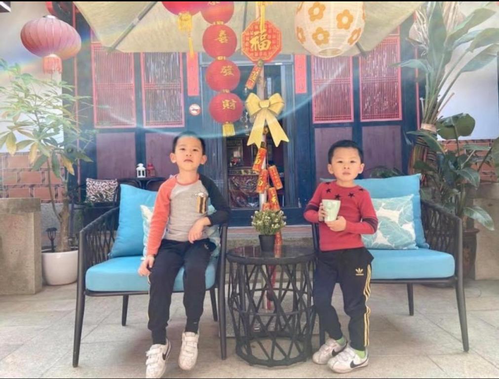 two young boys sitting on chairs in a room at I-Shan B&amp;B in Jincheng