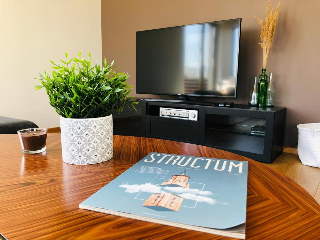 a book sitting on a table in front of a tv at House 3 Bedroom Vilnius in Vilnius