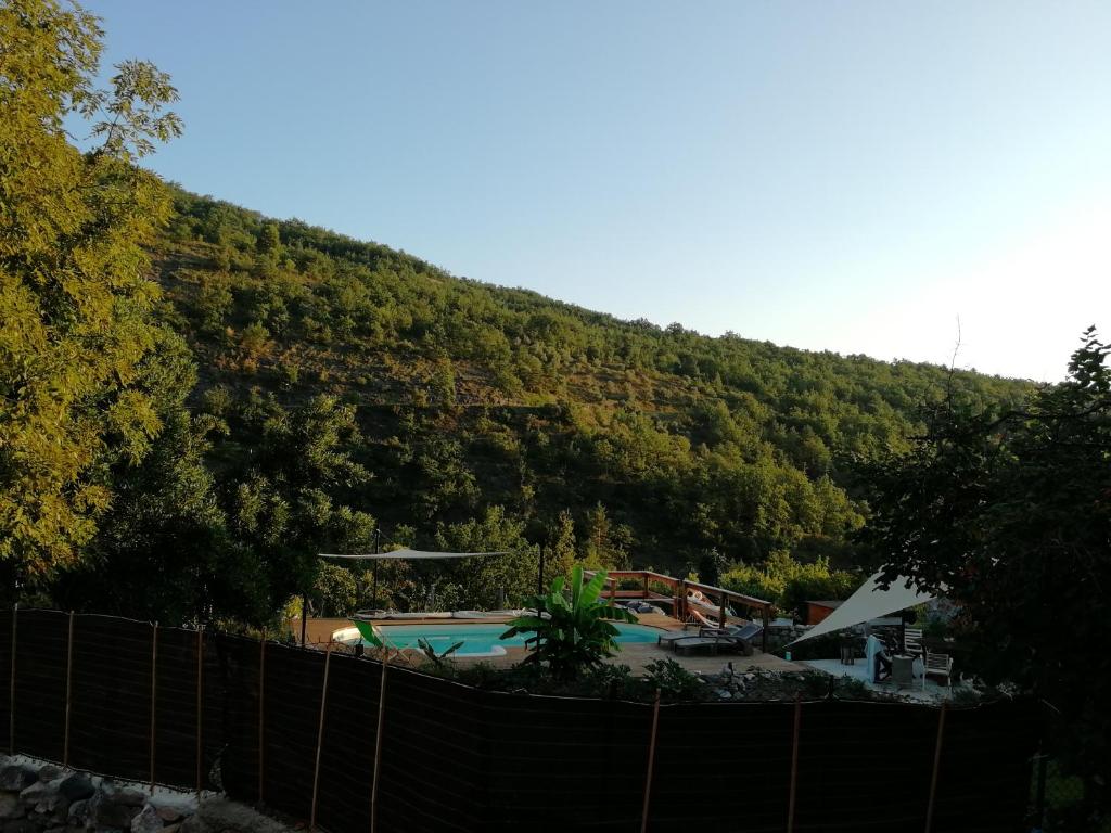 una piscina con una montaña en el fondo en Le Petit Chateau, en Ginoles