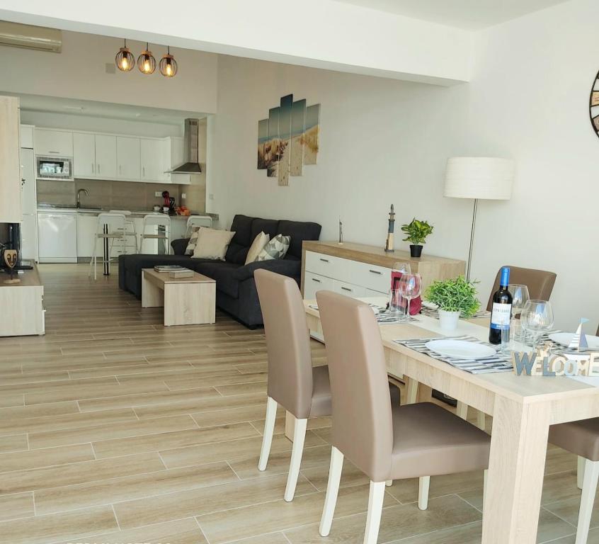 una sala da pranzo e un soggiorno con tavolo e sedie. di Villa Orquidea with private garden a Playa del Ingles