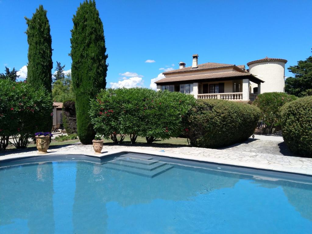 a large blue swimming pool in front of a house at Villa Liberty in Entraigues-sur-la-Sorgue