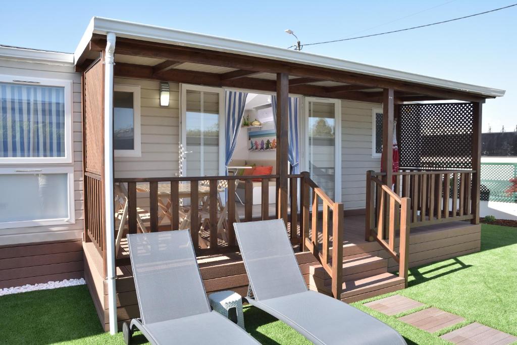 a screened in deck with chairs on the grass at Retiro da Praia da Aguda in Arcozelo