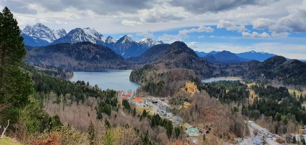 Elle offre une vue sur un lac et une ville dans les montagnes. dans l'établissement Ferienhaus Elisabeth, à Füssen