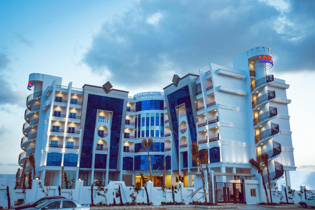 um grande edifício com palmeiras em frente em Lamar Azur Hotel em Dumyat al Jadidah