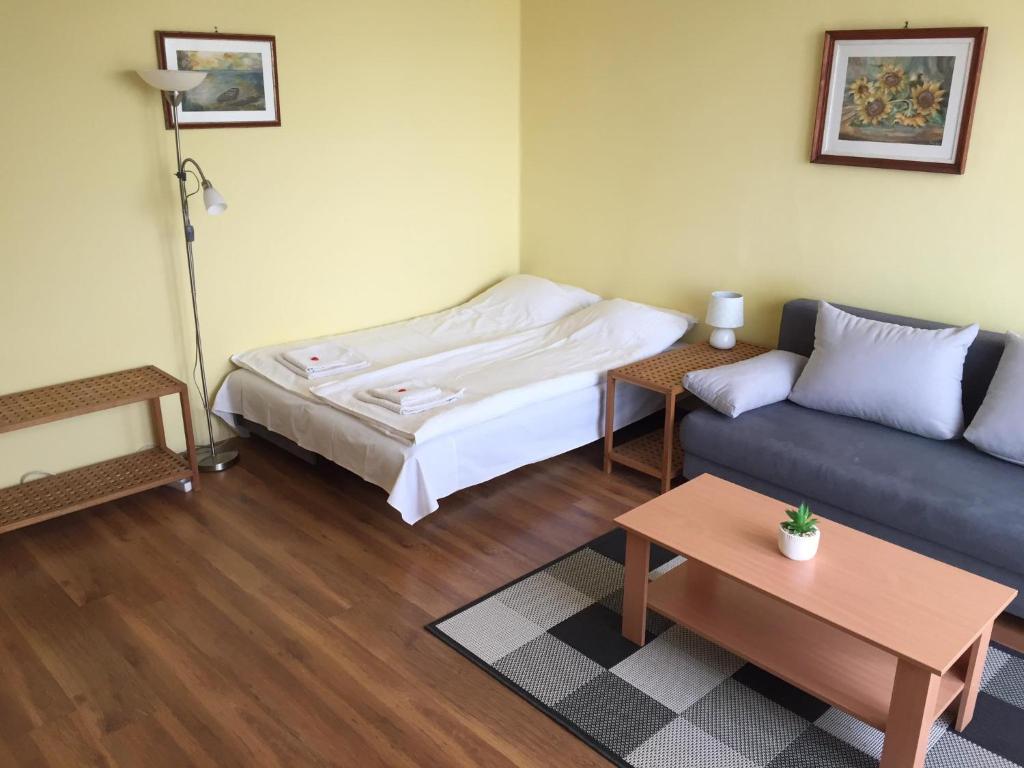 a living room with a bed and a couch at Szeki Apartman in Balatonfüred