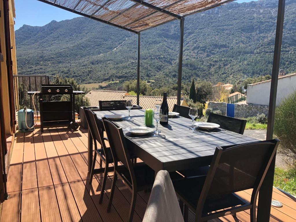 een tafel op een terras met uitzicht op een berg bij Gîte San Jordi in Duilhac