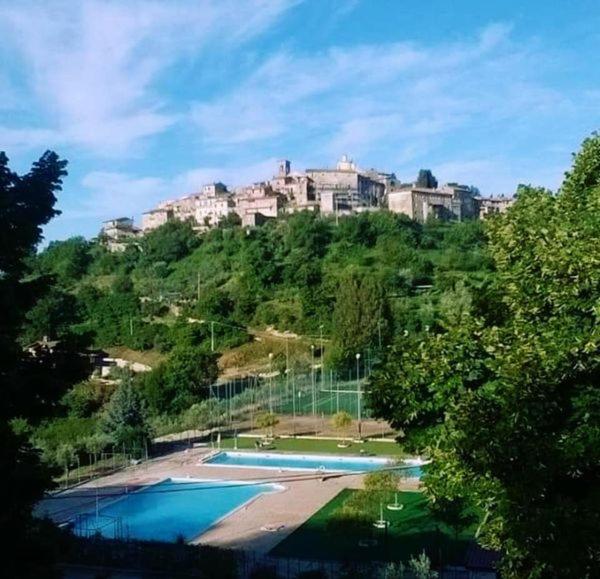 a building on top of a hill with two swimming pools at Residenza la Viola in Casaprota