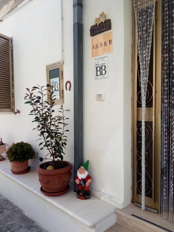 een veranda met planten en een bord op een gebouw bij Alfi BeB in Le Torri