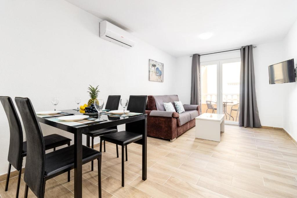 sala de estar con mesa, sillas y sofá en Apartment Cura Beach GALERA, en Torrevieja