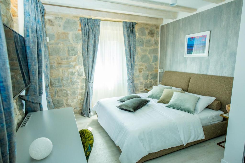 カシュテラにあるHeritage Villa Vitturi Sea Viewのベッドルーム1室(ベッド1台、ソファ、窓付)