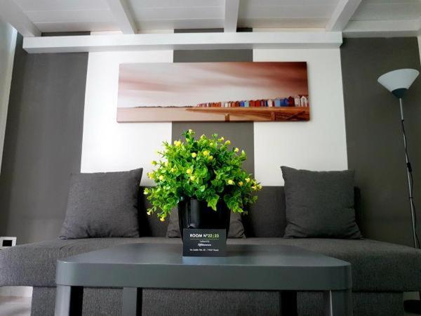 einen Tisch mit einer Blumenvase auf einer Couch in der Unterkunft room n.23 in Taranto
