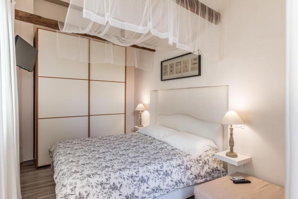 a bedroom with a bed with a white bedspread at The Bell in Comiso