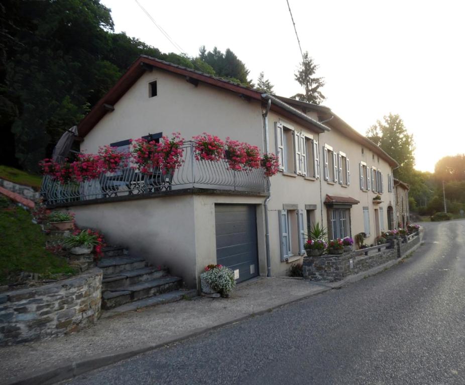 una casa con flores en los balcones de una calle en Le Pont de Livinhac, en Decazeville