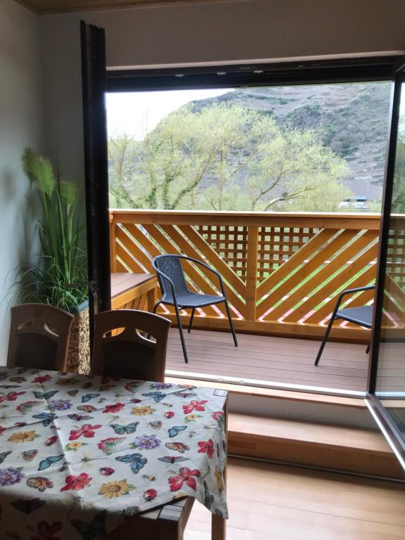 Zimmer mit einem Balkon mit Stühlen und einem Tisch in der Unterkunft Ferienwohnung Brinkmann 4**** mit Moselblick in Dieblich