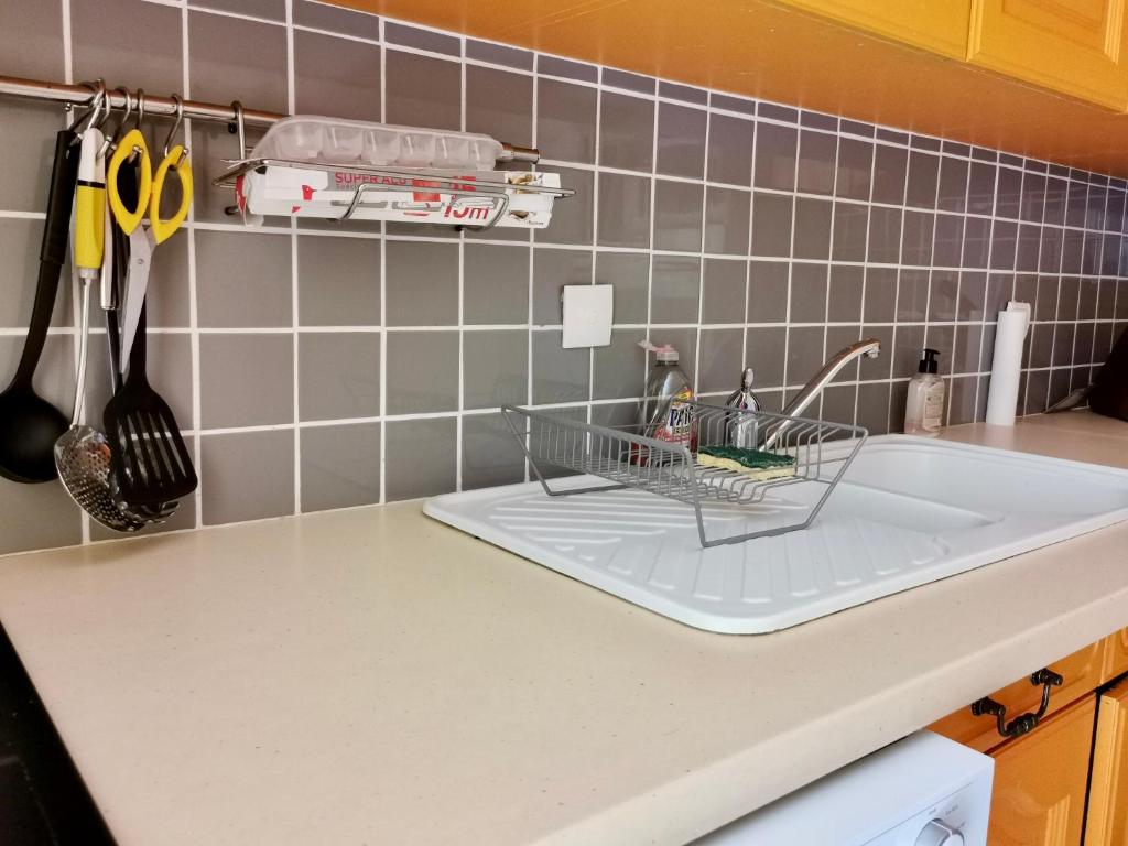 a kitchen sink with a dish drying rack and scissors at COC - La Belle Etoile in Wissant