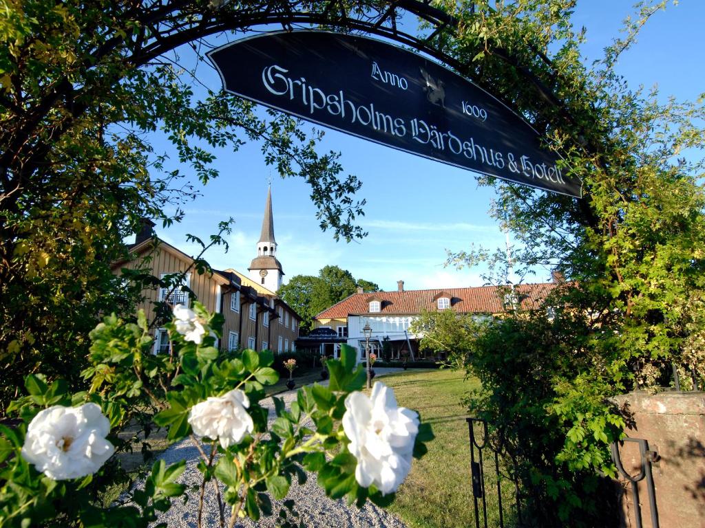 un letrero de la calle con flores y una iglesia al fondo en Gripsholms Värdshus en Mariefred