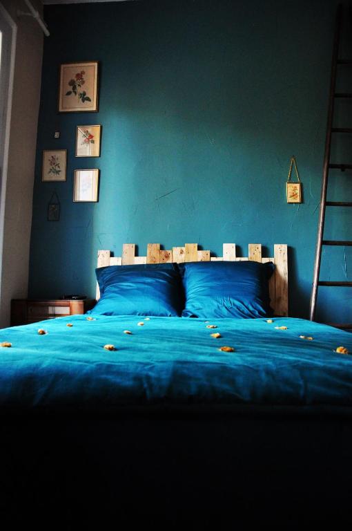 - un lit bleu avec une tête de lit en bois dans une chambre dans l'établissement ✿ L'Escapade Occitane ✿(Occitan Getaway) - Arceaux, à Montpellier