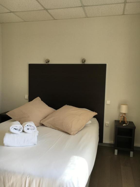 a bedroom with a large bed with two towels on it at Les Bains Boyardville - Hôtel et Restaurant in Boyard-Ville