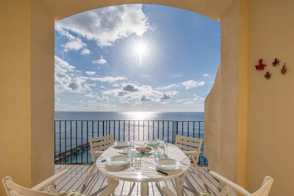 a table on a balcony with a view of the ocean at La Casa del Mare in Nerano