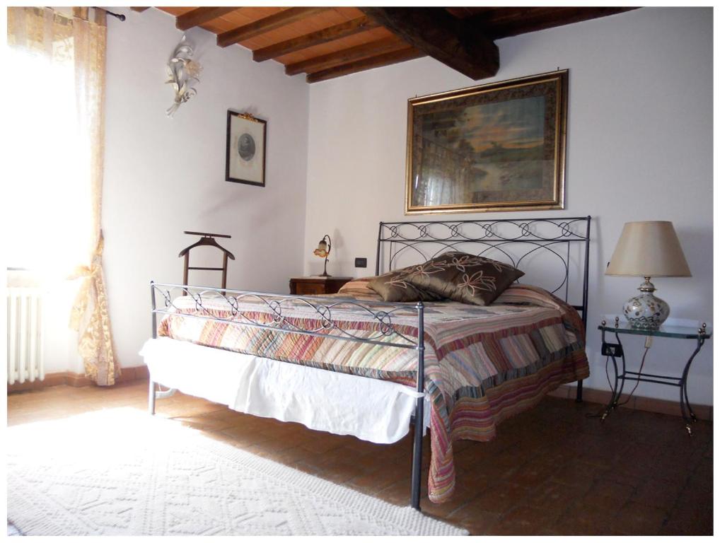 1 dormitorio con 1 cama y 1 mesa con lámpara en La Pieve Di Sant'Andrea, en Maggiano