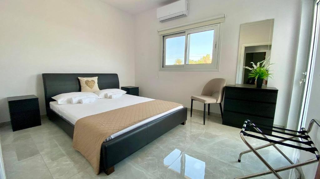 a bedroom with a bed and a chair and a window at Napa Court 2 in Ayia Napa