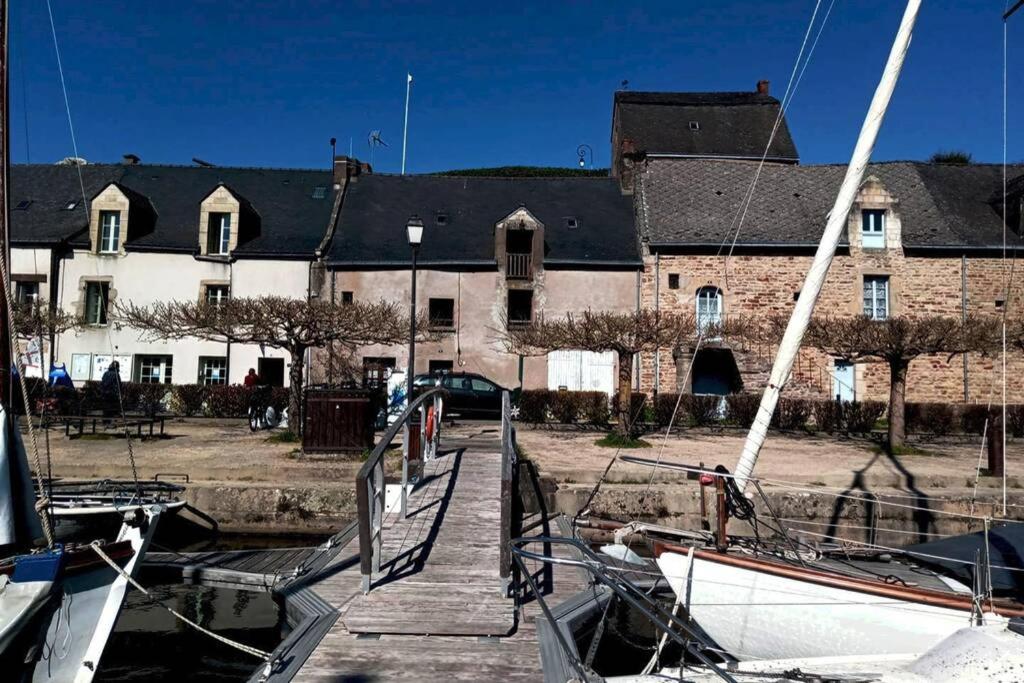 a boat docked in front of a large building at Maison Bretagne proche Penestin port La Roche Bernard 5 à 6 pers in La Roche-Bernard