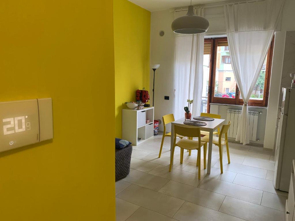 a dining room with yellow walls and a table and chairs at Alleria Holiday Home in Salerno