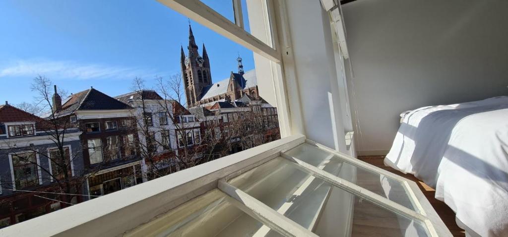 um quarto com uma janela com vista para a cidade em Appartement Mes Amis Delft em Delft