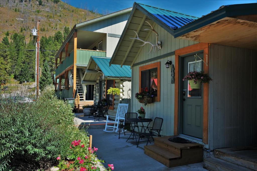 une terrasse couverte d'une maison avec des chaises et une table dans l'établissement Elk Horn Lodge, à Cooke City