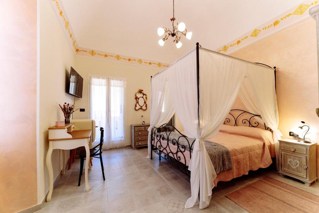 1 dormitorio con cama con dosel y escritorio en Come Nelle Favole the Classic B&B, en Toirano